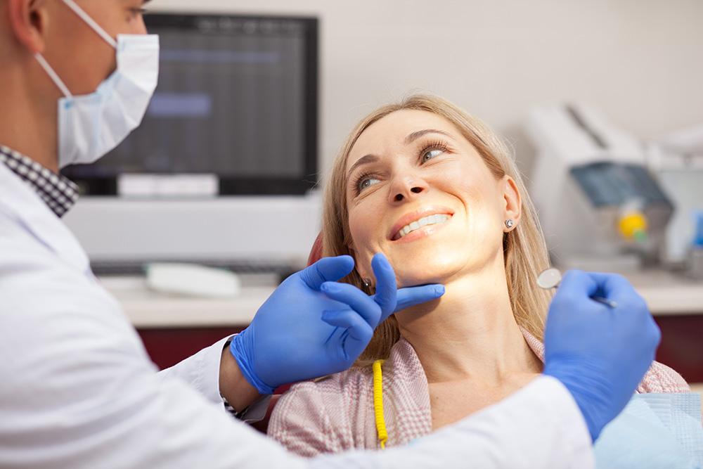 Cheerful mature woman smiling happily at her dentist